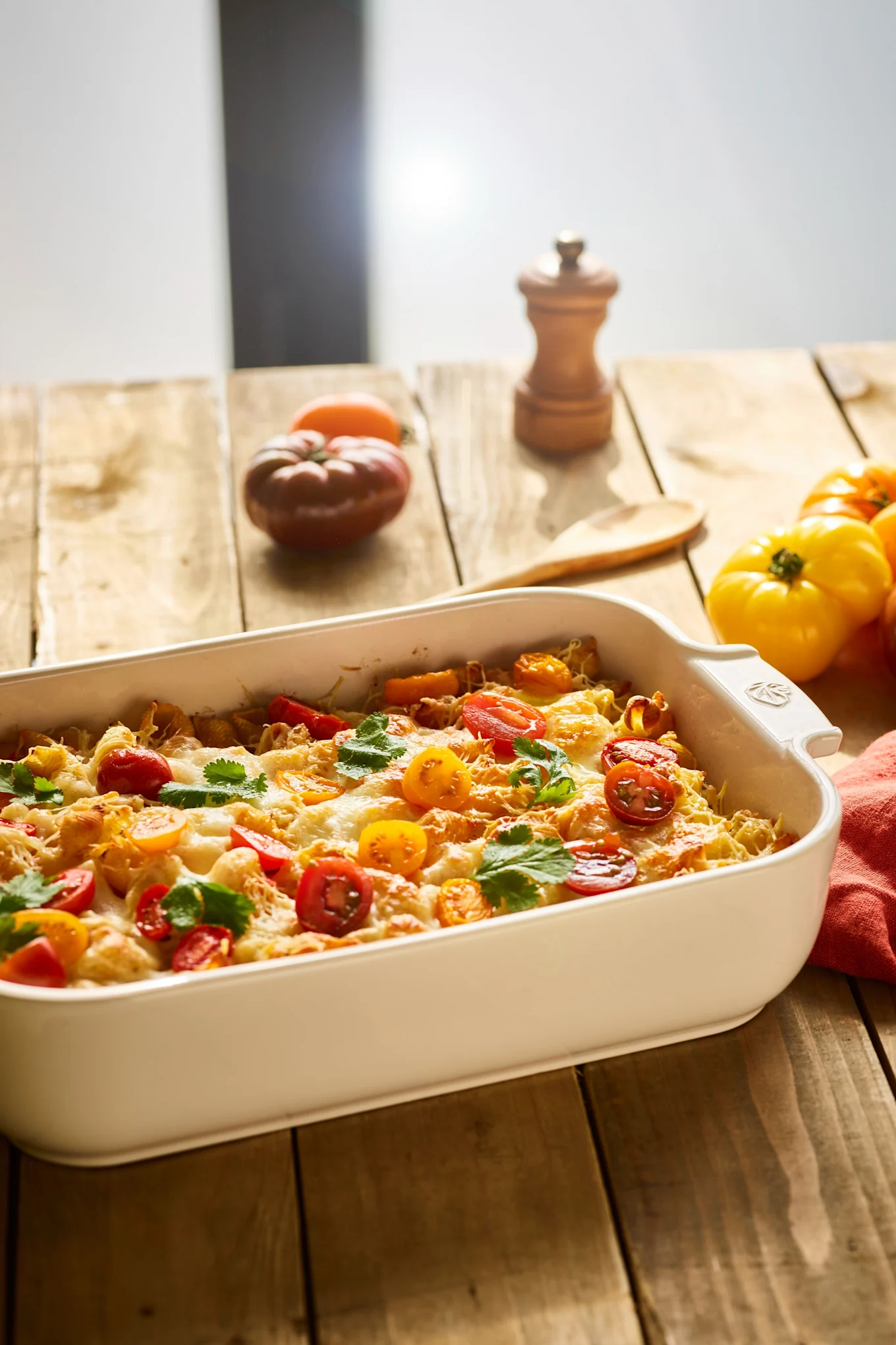 Die Appolia-Keramikform von Peugeot steht auf einem Holztisch und enthält einen Auflauf.