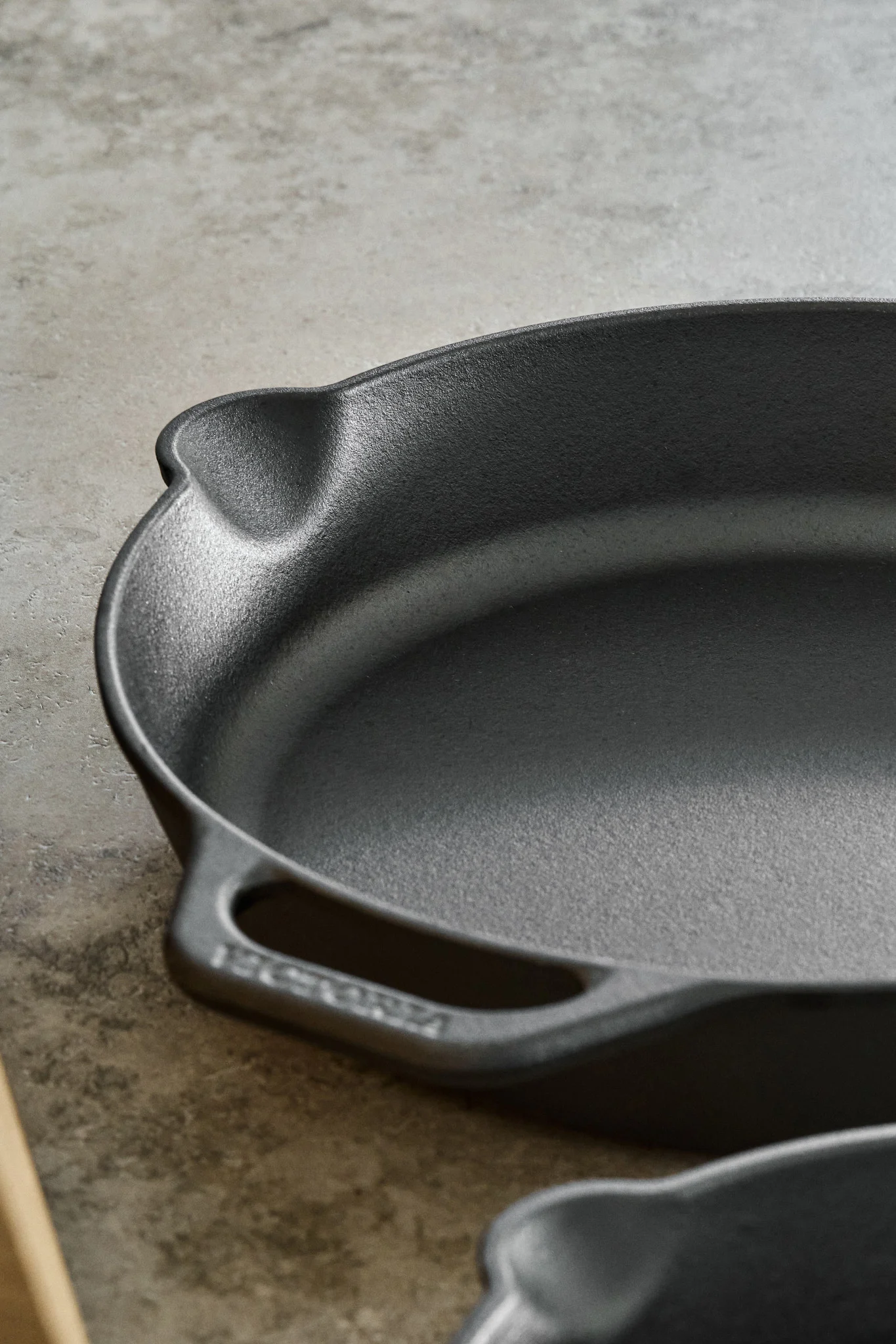 Nahaufnahme einer gusseisernen Pfanne mit Ausguss und Griff. 