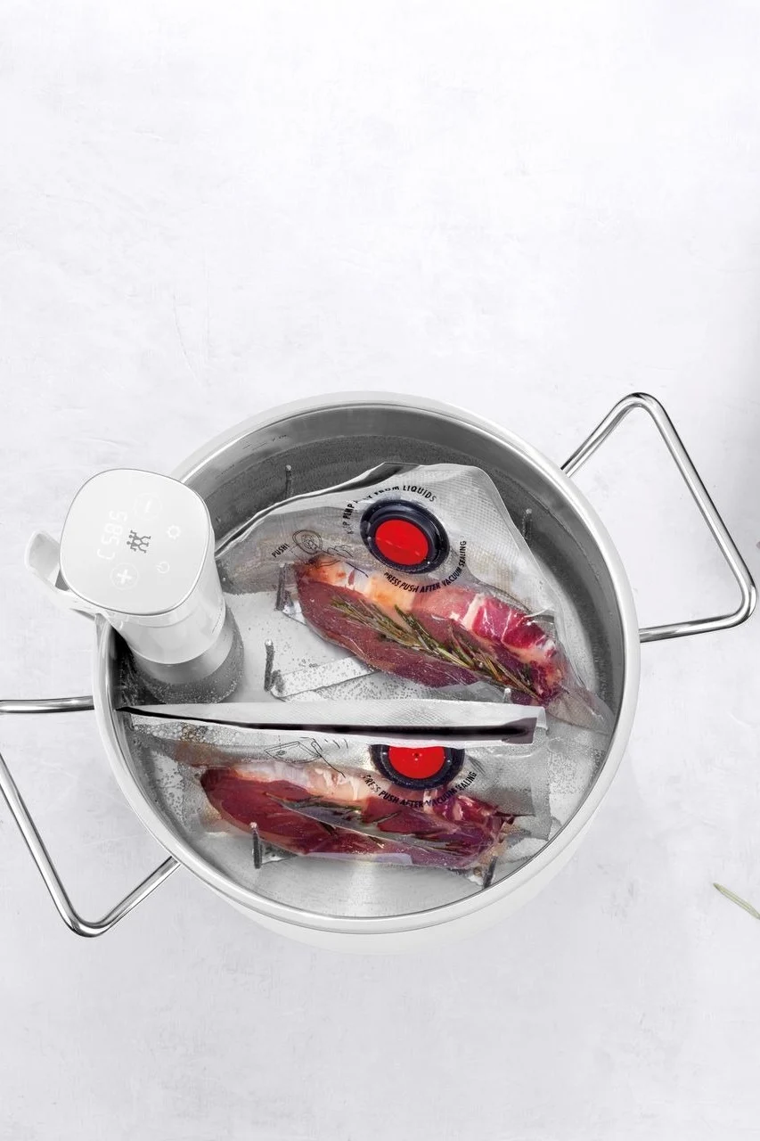 Vakuumieren Sie das Steak mit Kräutern und legen Sie es in einen Topf mit Wasser, um die perfekte Garstufe zu erreichen.