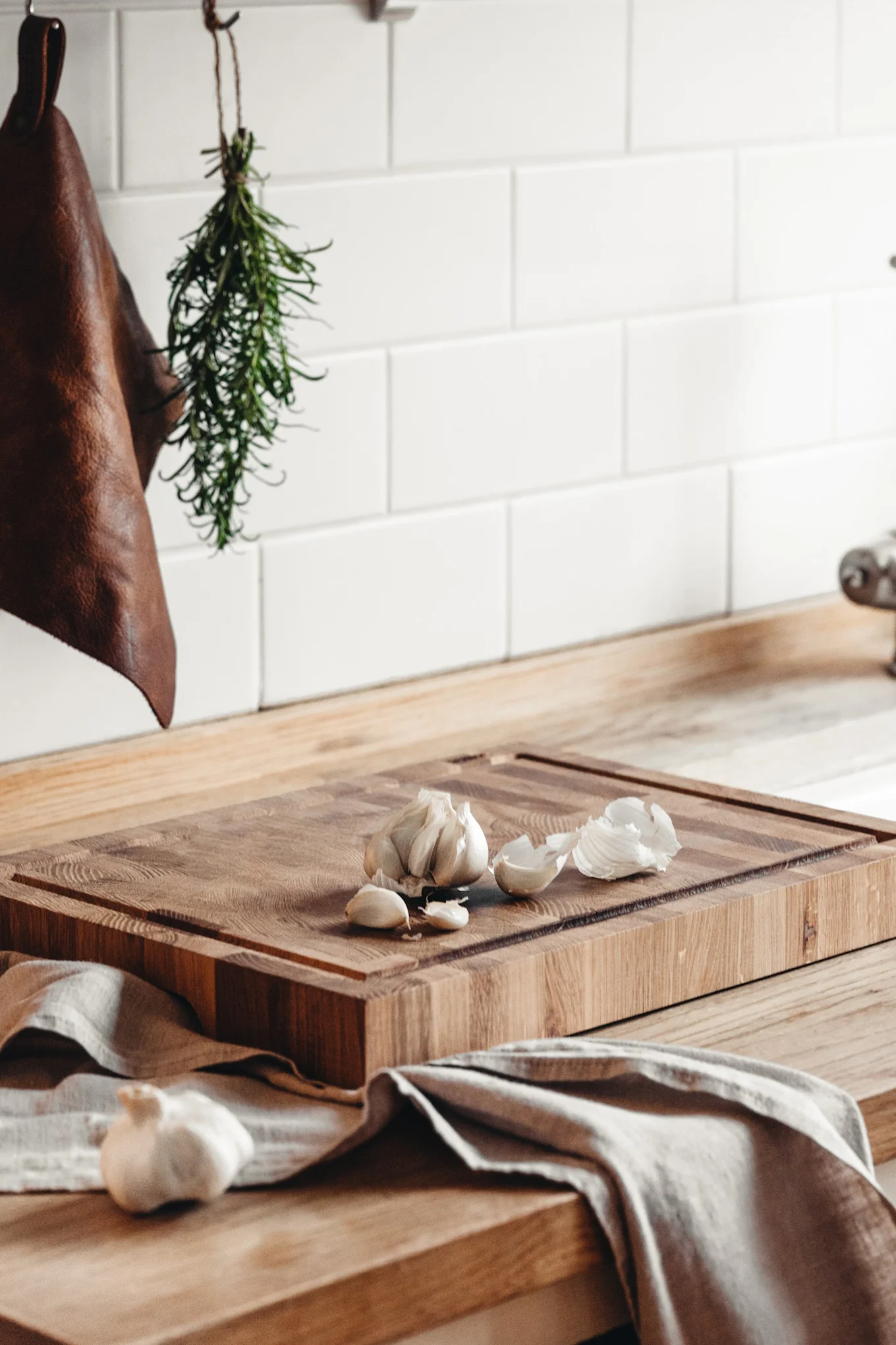 Das hölzerne Schneidebrett von Heirol liegt mit Knoblauch auf einer Küchenanrichte.