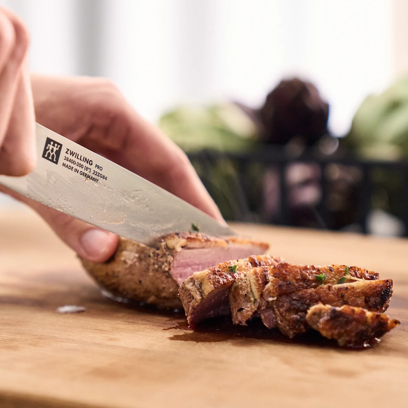 Ein perfekt gebratenes Schweinefilet wird mit dem Pro-Messer von Zwilling in Scheiben geschnitten.