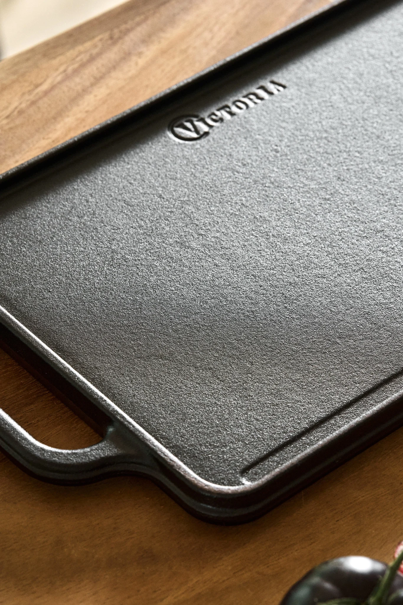 Eine wendbare Kochplatte aus Gusseisen auf einer Küchenzeile aus Holz. 