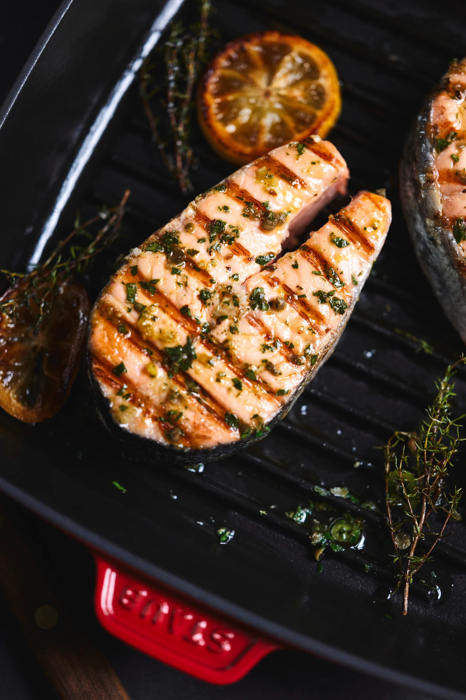 In einer Grillpfanne wird ein ganzes Stück Lachs gebraten.