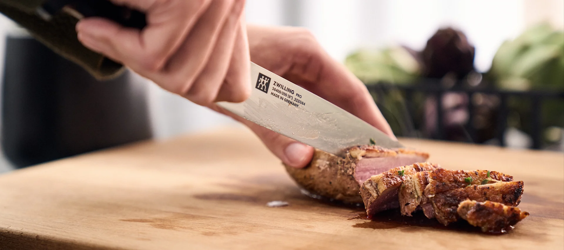 Ein perfekt gebratenes Schweinefilet wird mit dem Pro-Messer von Zwilling in Scheiben geschnitten.
