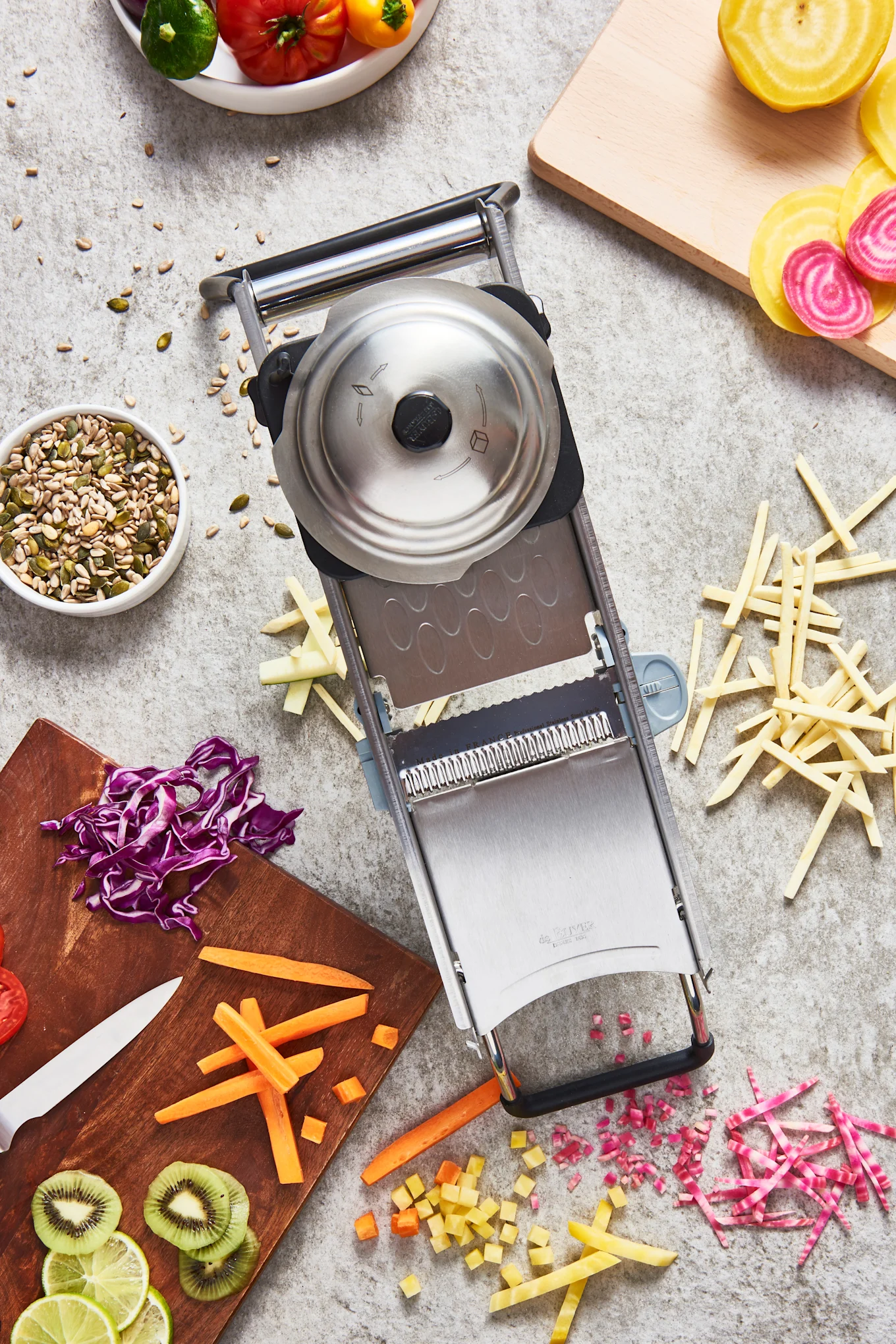 Reiben Sie verschiedenes Gemüse in verschiedene Formen mit der Revolution Mandoline von De Buyer.